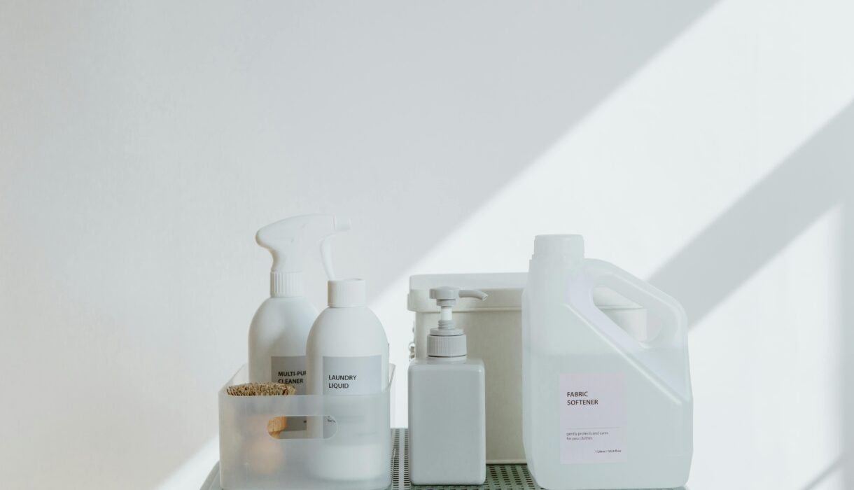 Clean and simple display of various cleaning products in soft lighting on a white background.